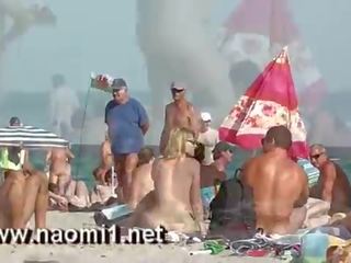 Naomi1 paja un joven youth en un público playa
